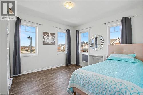 Interior room featuring rich wood-finish flooring, white walls, and multiple windows - 60 Postmaster Drive, Kitchener, ON - Indoor Photo Showing Bedroom