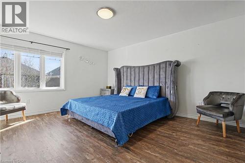 Spacious room featuring wood-finish flooring, white walls, and a large multi-pane window with white trim - 60 Postmaster Drive, Kitchener, ON - Indoor Photo Showing Bedroom