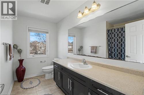 Bathroom featuring a dark wood-finish vanity with a light-colored countertop and integrated sink - 60 Postmaster Drive, Kitchener, ON - Indoor Photo Showing Bathroom