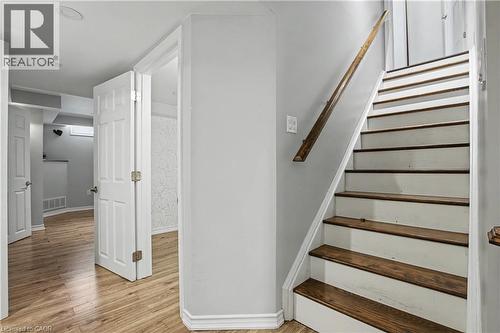Interior staircase featuring wood-finish treads and a coordinating wood handrail - 60 Postmaster Drive, Kitchener, ON - Indoor Photo Showing Other Room