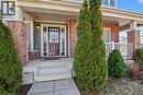 Covered front porch featuring brick pillars and a paneled front door with sidelights - 60 Postmaster Drive, Kitchener, ON  - Outdoor 
