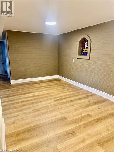 Light wood-finish flooring with crisp white baseboards - 63 Audrey Street, Hamilton, ON - Indoor Photo Showing Other Room