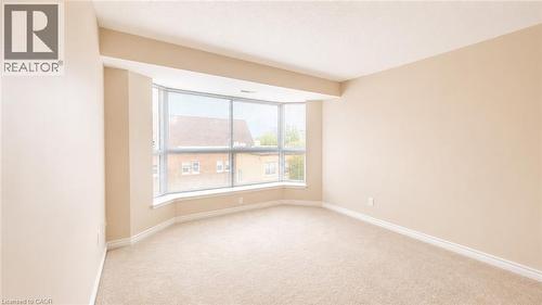 Room featuring a bay window, neutral carpeting, and light-toned wall paint - 20 St. George Street Unit# 404, Kitchener, ON - Indoor Photo Showing Other Room