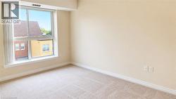 Bright room featuring a large window, neutral carpet flooring, light-toned walls, and white baseboards - 