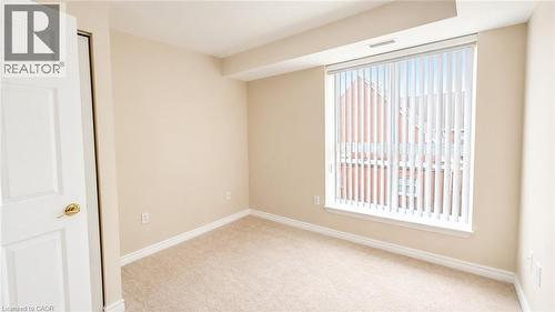 Neutral-toned room featuring light beige walls and complementing carpet flooring - 20 St. George Street Unit# 404, Kitchener, ON - Indoor Photo Showing Other Room