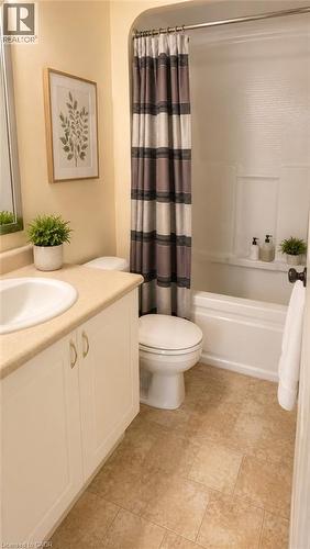 Full bathroom featuring a white tub/shower combination, a white toilet, and a vanity with an integrated sink and light-colored countertop - 20 St. George Street Unit# 404, Kitchener, ON - Indoor Photo Showing Bathroom