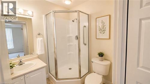 Corner glass-enclosed shower with grab bars - 20 St. George Street Unit# 404, Kitchener, ON - Indoor Photo Showing Bathroom