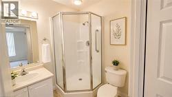 Corner glass-enclosed shower with grab bars - 
