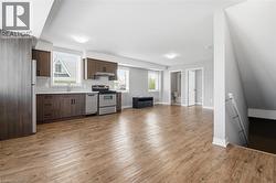 Open-concept living area featuring wood-finish flooring throughout - 