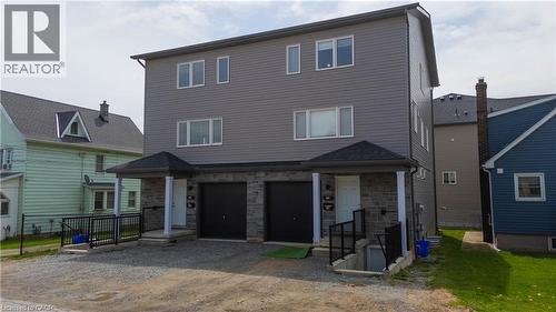Modern duplex exterior featuring gray siding and stone veneer accents - 3 Hagar Street, Thorold, ON - Outdoor
