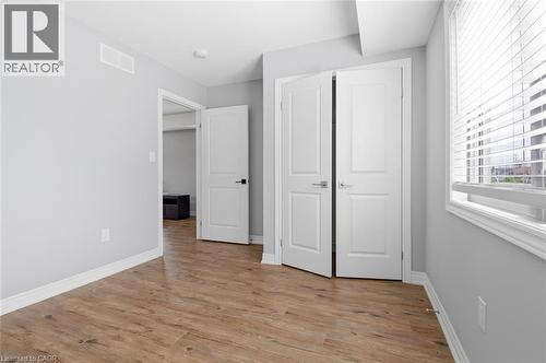 Room featuring wood-finish flooring, light grey painted walls, white trim, and a window with blinds - 3 Hagar Street, Thorold, ON - Indoor Photo Showing Other Room