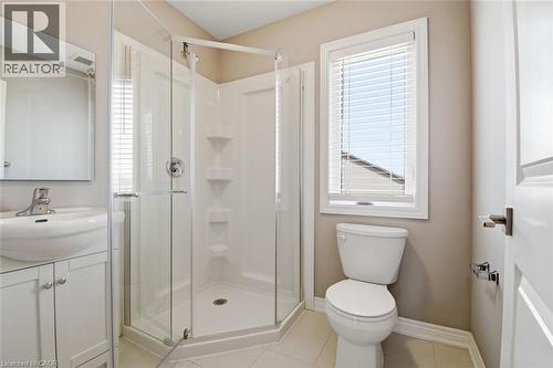 Bathroom featuring a glass-enclosed shower, white vanity with integrated sink, toilet, and a window with blinds - 3 Hagar Street, Thorold, ON - Indoor Photo Showing Bathroom