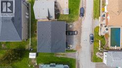 Property featuring a dark shingle roof, green lawn, and a paved driveway - 