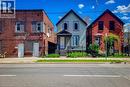 Gabled residence featuring light-colored siding, contrasting dark trim, and a covered front entry - 334 Gage Avenue N, Hamilton, ON  - Outdoor With Facade 