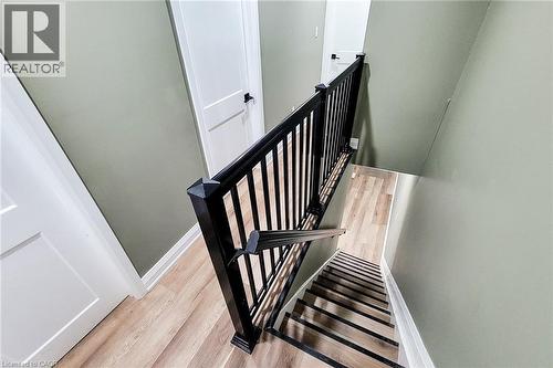 Stairwell featuring modern black railings, light wood-finish flooring, and light green wall paint - 334 Gage Avenue N, Hamilton, ON - Indoor Photo Showing Other Room
