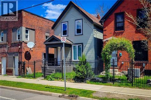 Gabled facade with light-toned siding, black trim, and a covered front porch entry - 334 Gage Avenue N, Hamilton, ON - Outdoor With Facade