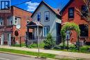 Gabled facade with light-toned siding, black trim, and a covered front porch entry - 334 Gage Avenue N, Hamilton, ON  - Outdoor With Facade 