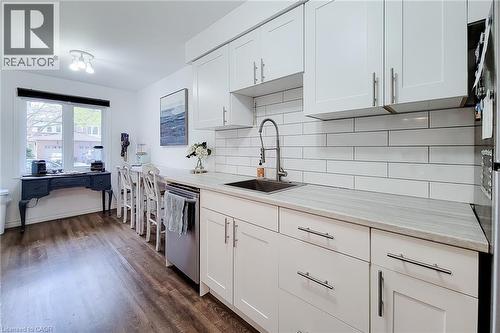 Modern kitchen featuring white shaker cabinetry, stainless steel sink with gooseneck faucet, light-toned countertops, and subway tile backsplash - 7 Davidson Boulevard Unit# 14, Dundas, ON - Indoor Photo Showing Kitchen With Upgraded Kitchen