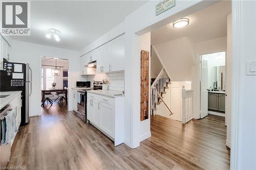 Modern kitchen featuring white shaker cabinetry, stainless steel appliances, light countertops, and a subway tile backsplash - 7 Davidson Boulevard Unit# 14, Dundas, ON - Indoor Photo Showing Kitchen