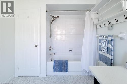 Bathroom featuring a white subway tile tub surround, chrome shower fixtures, and a six-panel door - 7 Davidson Boulevard Unit# 14, Dundas, ON - Indoor