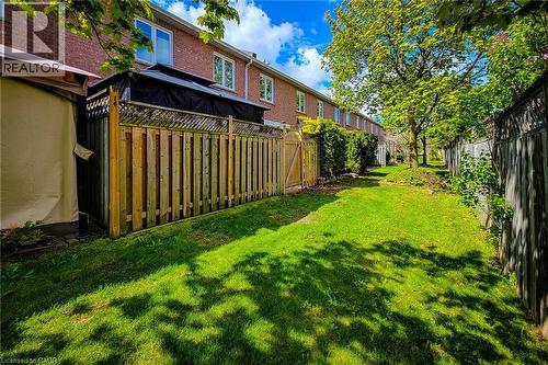 Expansive green space featuring a manicured lawn, established perimeter fencing, and mature trees - 7 Davidson Boulevard Unit# 14, Dundas, ON - Outdoor