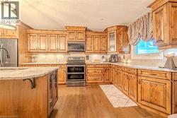 Kitchen featuring wood-finish cabinetry, light-toned countertops, and a subway tile backsplash - 