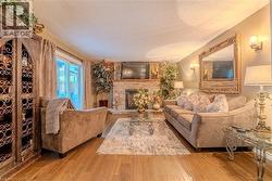 Living area featuring wood-finish flooring, a stone-faced fireplace with a hearth, and a large sliding glass door - 
