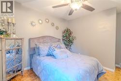 Recessed ceiling fan with integrated lighting, paneled parquet flooring, and crisp white baseboards - 