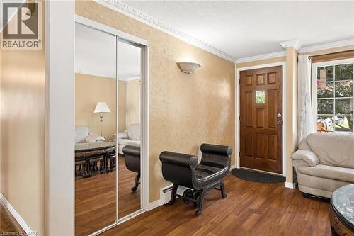 Entryway featuring wood-finish flooring, a paneled solid wood door with a transom window, and crown molding - 162 Tiffany Street, Cambridge, ON - Indoor