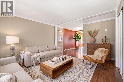 VIRTUALLY STAGED. Spacious living area featuring elegant crown molding and wood-finish flooring - 162 Tiffany Street, Cambridge, ON - Indoor Photo Showing Living Room