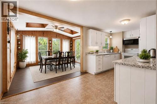 VIRTUALLY STAGED. Sunroom dining area with vaulted wood-panelled ceiling, ceiling fan, and multiple windows - 162 Tiffany Street, Cambridge, ON - Indoor