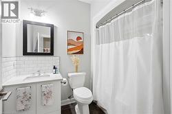 Bathroom featuring a white subway tile backsplash and a vanity with a white countertop - 