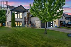 Modern stucco and stone facade with a dark shingle roof - 