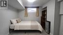 Carpeted room featuring a built-in wooden shelving unit, a single window with natural light, and a flush-mount ceiling light fixture - 10 Doll Court, Kitchener, ON  - Indoor Photo Showing Bedroom 