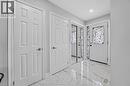 Foyer featuring high-gloss marbled tile flooring, a white paneled entry door with decorative ironwork, and mirrored closet doors - 3346 Chartrand Crescent, Mississauga, ON  - Indoor Photo Showing Other Room 