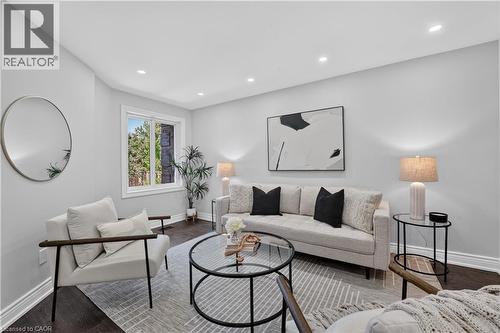 Recessed ceiling lighting illuminates this living space featuring dark wood-finish flooring and light gray wall paint - 3346 Chartrand Crescent, Mississauga, ON - Indoor Photo Showing Living Room