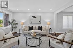Spacious living area featuring recessed lighting, dark wood-finish flooring, a large window with white trim, and a wide entryway - 