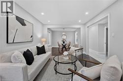 Open-concept living area featuring recessed lighting, dark wood-finish flooring, light grey wall tones, and white trim throughout - 
