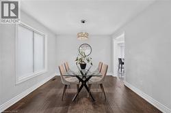 Interior room featuring wood-finish flooring, white baseboards, and light-toned walls - 