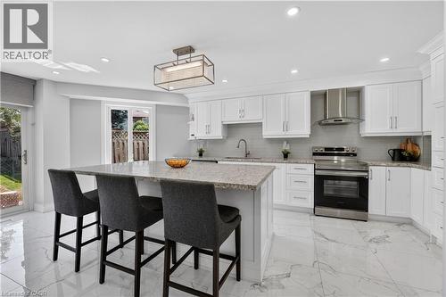 Modern kitchen featuring white cabinetry, a large center island with a speckled countertop, integrated stainless steel appliances, a white subway tile backsplash, and polished marble-look flooring - 3346 Chartrand Crescent, Mississauga, ON - Indoor Photo Showing Kitchen With Upgraded Kitchen