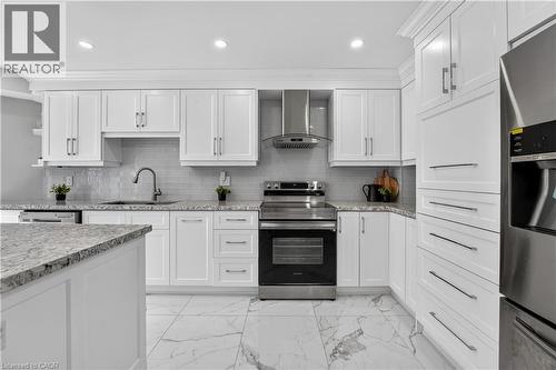 Kitchen featuring white shaker-style cabinetry, stainless steel appliances, speckled stone countertops, and a subway tile backsplash - 3346 Chartrand Crescent, Mississauga, ON - Indoor Photo Showing Kitchen With Upgraded Kitchen