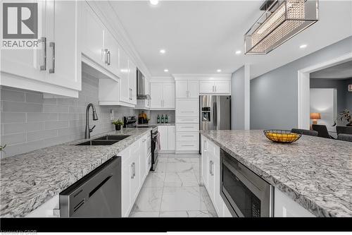 Kitchen featuring white cabinetry, light granite countertops, a tile backsplash, stainless steel appliances, and recessed lighting - 3346 Chartrand Crescent, Mississauga, ON - Indoor Photo Showing Kitchen With Double Sink With Upgraded Kitchen