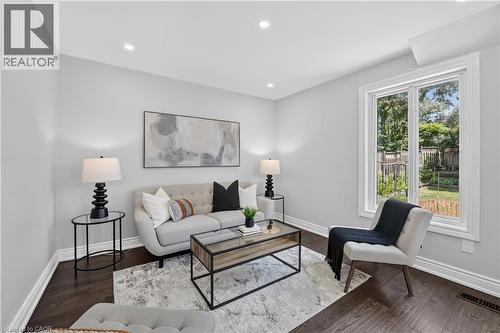 Bright living area featuring wood-finish flooring, recessed lighting, and a large window overlooking a landscaped yard - 3346 Chartrand Crescent, Mississauga, ON - Indoor Photo Showing Living Room