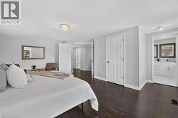 Spacious room featuring dark wood-finish flooring, light grey walls, and white trim - 