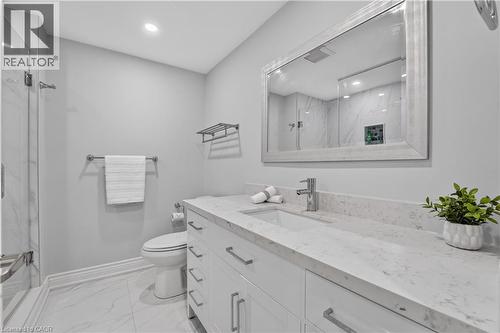 Bathroom featuring a spacious white vanity with an integrated sink, a large framed mirror, and a glass-enclosed shower with white marble-style wall tiling - 3346 Chartrand Crescent, Mississauga, ON - Indoor Photo Showing Bathroom