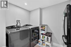 Laundry area featuring a ceiling-mounted recessed light, light gray walls, and a white baseboard trim - 