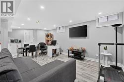 Spacious living area featuring light-toned wood-finish flooring, recessed lighting, and a neutral wall color - 