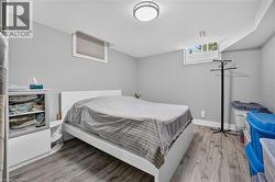 Bedroom featuring wood-finish flooring, light gray wall paint, and two windows - 
