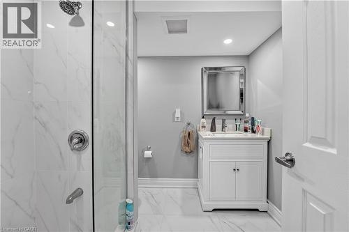Bathroom featuring a glass-enclosed shower with white marble-look tile, a white vanity with an integrated sink, a rectangular framed mirror, recessed lighting, and a white paneled door - 3346 Chartrand Crescent, Mississauga, ON - Indoor Photo Showing Bathroom