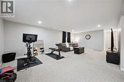 Expansive lower-level space featuring light-colored carpeting, recessed lighting, and neutral wall paint - 